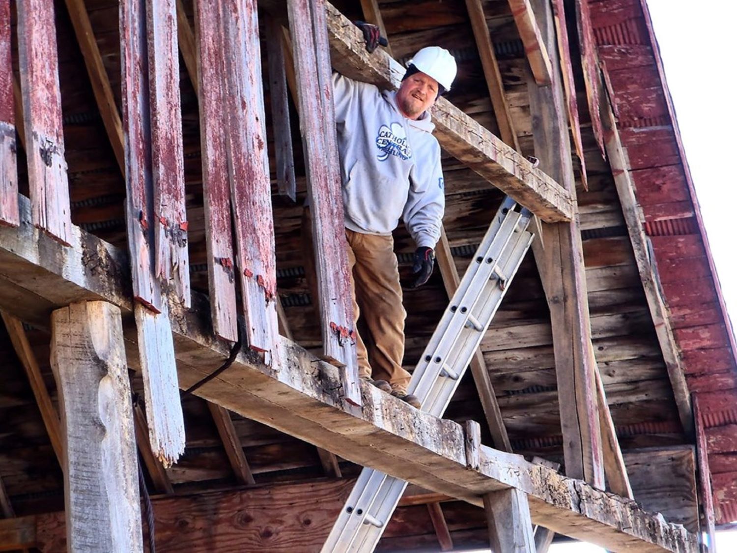 Owner, Jim, standing on the belly beam of a barn in Saginaw, MI