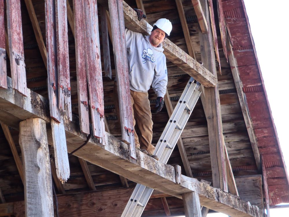 Jim standing on a belly beam in a 120 year old barn in Linwood, MI